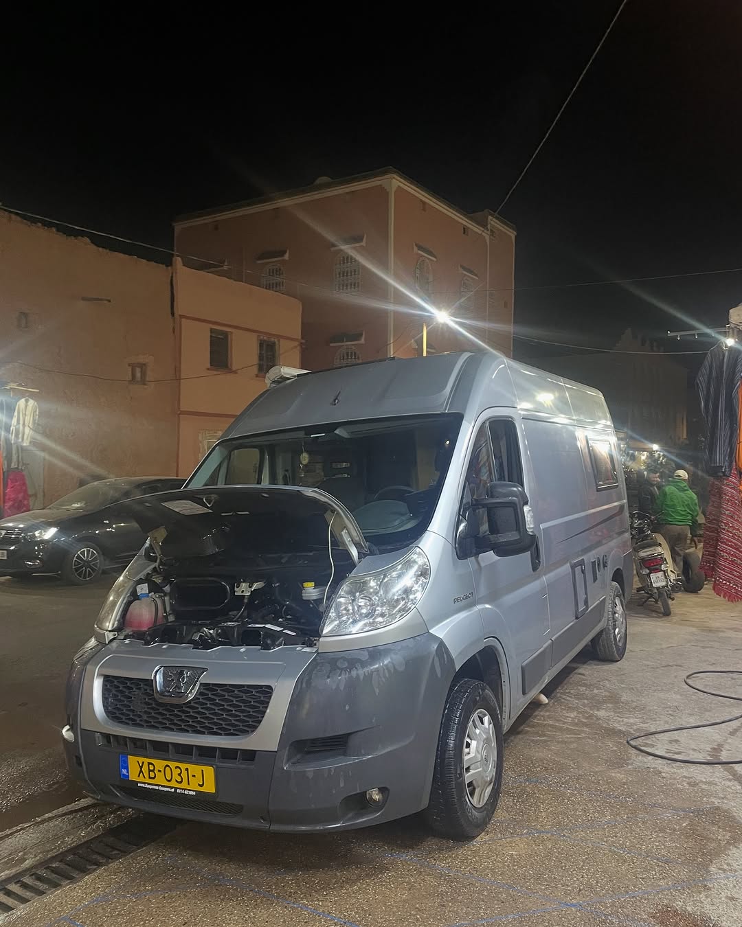 Silver Peugeot Boxer camper with Dutch plate XB-031-J parked at night in Zagora, hood open after arriving at the workshop