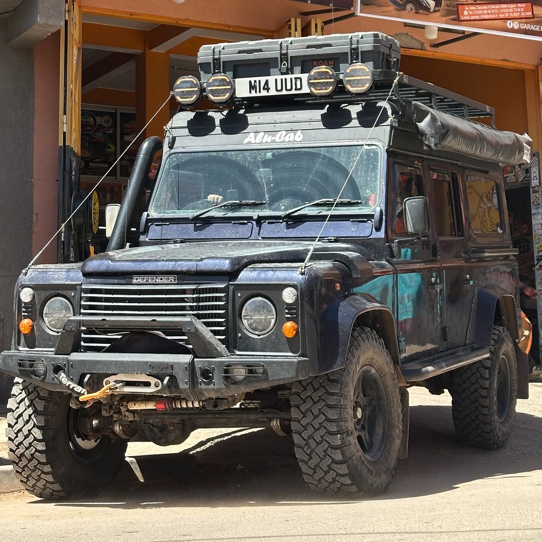 Front view of a British Land Rover Defender 110 with roof rack, LED spotlights and winch outside Garage Iriki Zagora