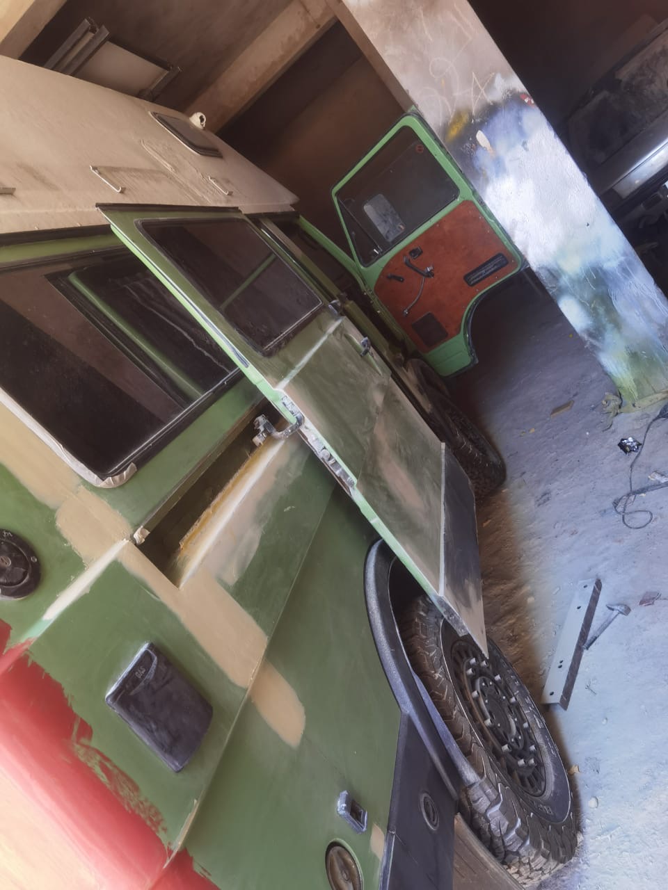 VW camper cab and body prepped in green primer inside the Garage Iriki bodyshop before final colour