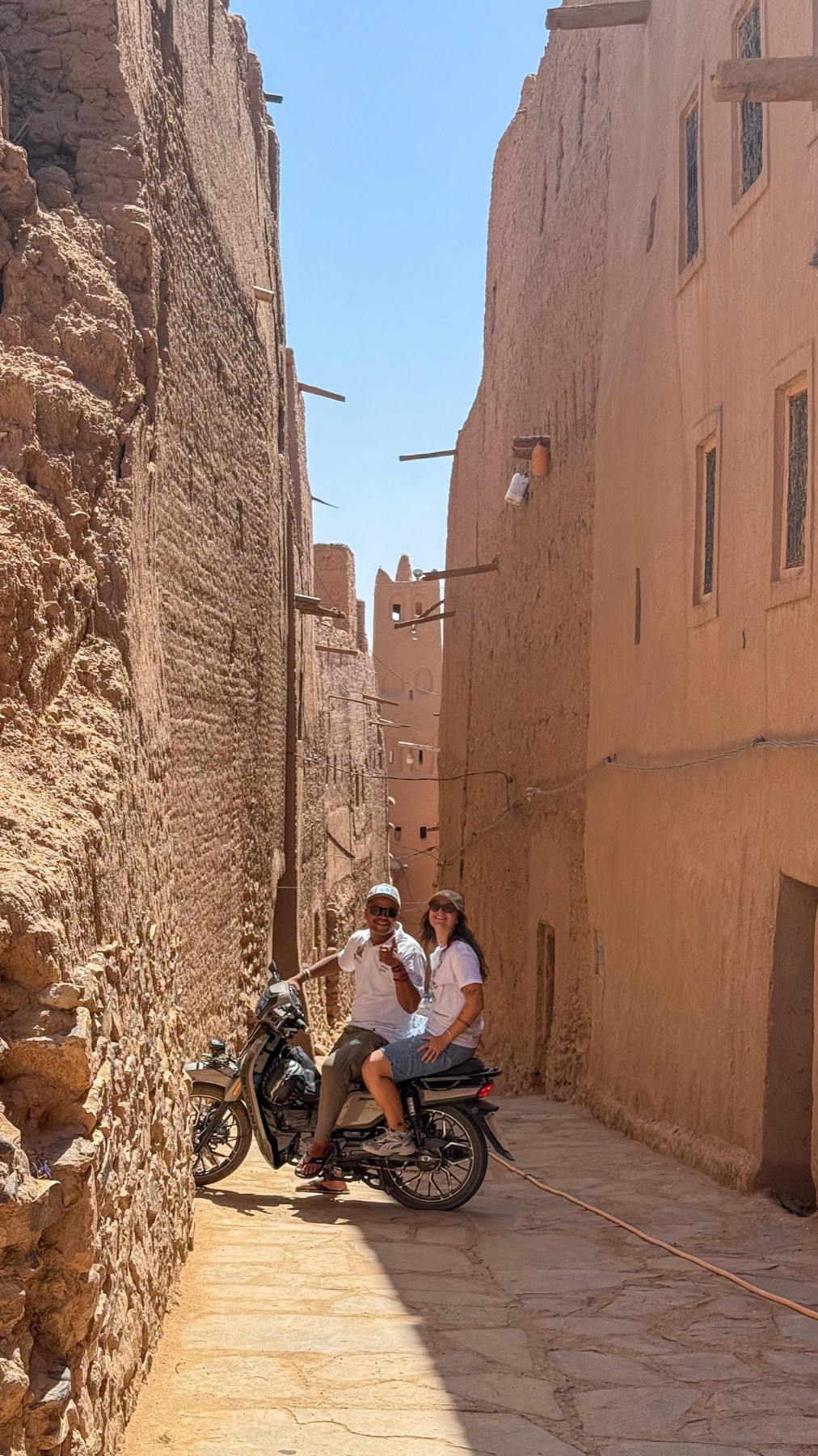 Travellers exploring the earthen streets around Zagora by motorcycle