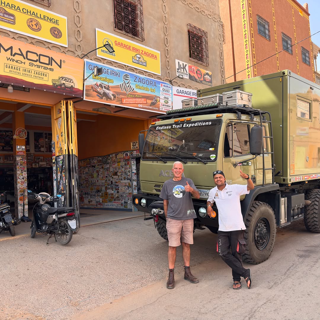 Paul from Endless Trail Expeditions and Zicaaaas mechanic in front of the green Acela 6x6 Bliss Mobil expedition truck at Garage Iriki Zagora