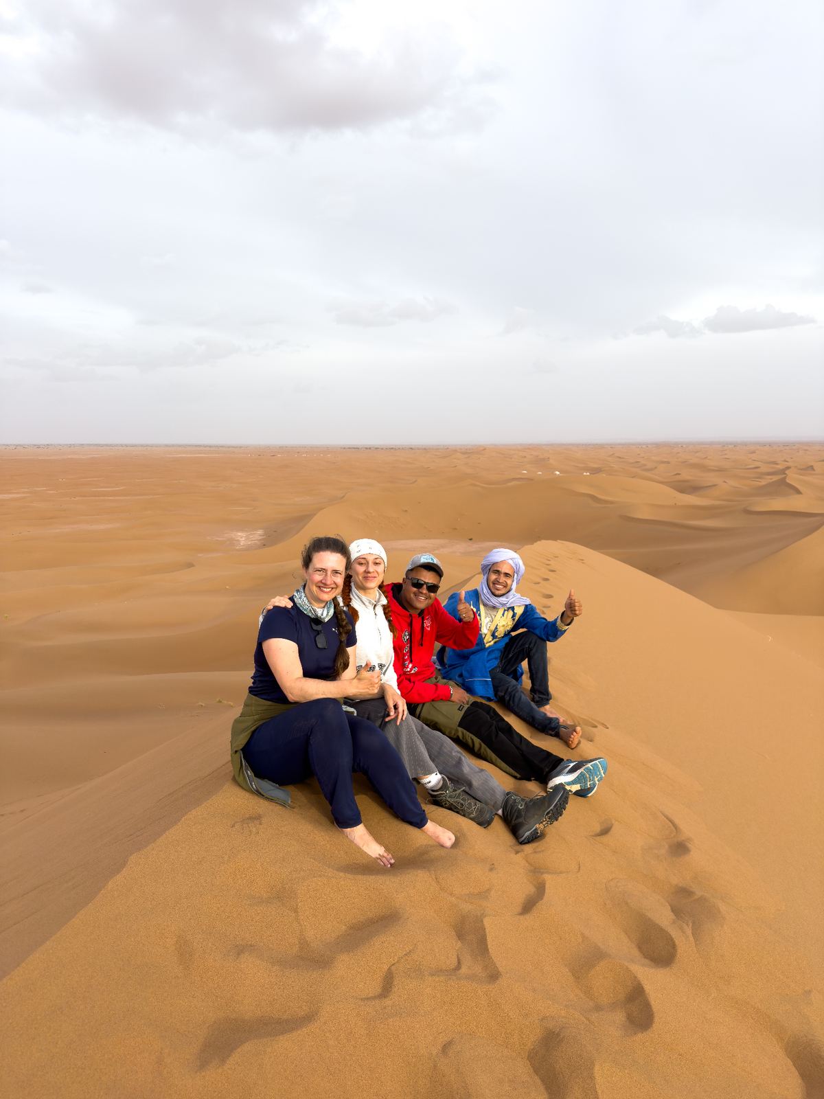 Four people on a high sand dune
