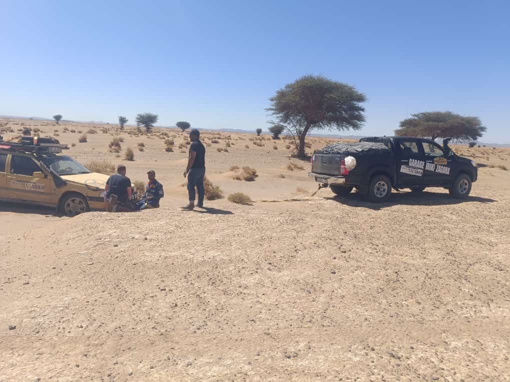 Iriki Hilux towing a rally car through the desert