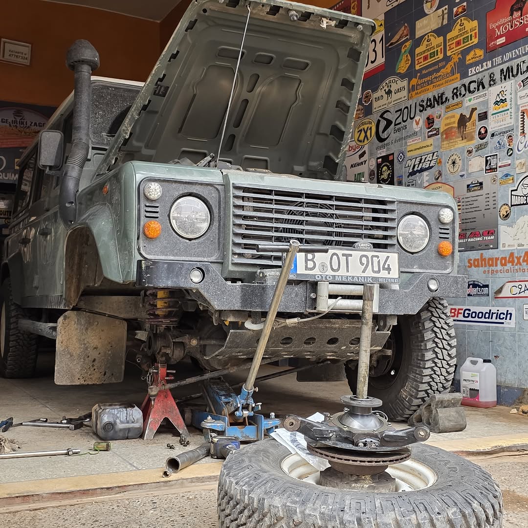 German Land Rover Defender with hood open on axle stands during oil leak repair at Garage Iriki Zagora