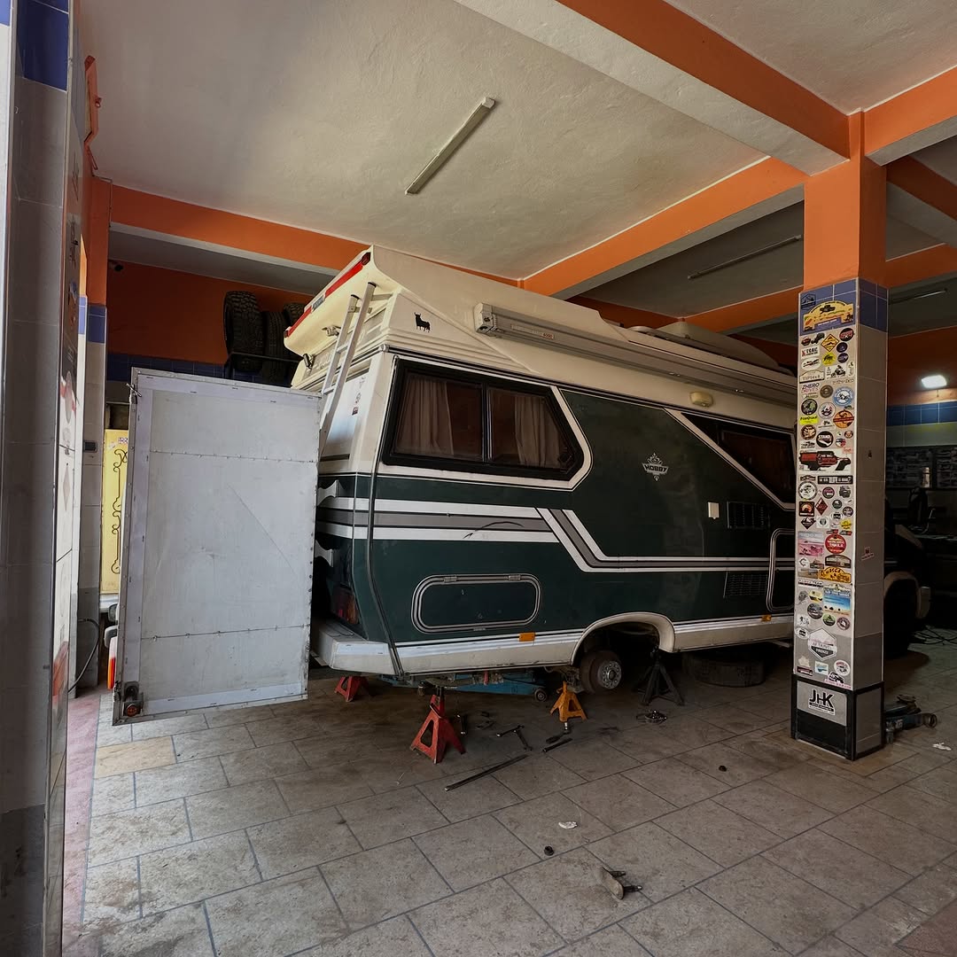 Austrian Turbo D camper on axle stands inside Garage Iriki workshop during extra leaf spring installation