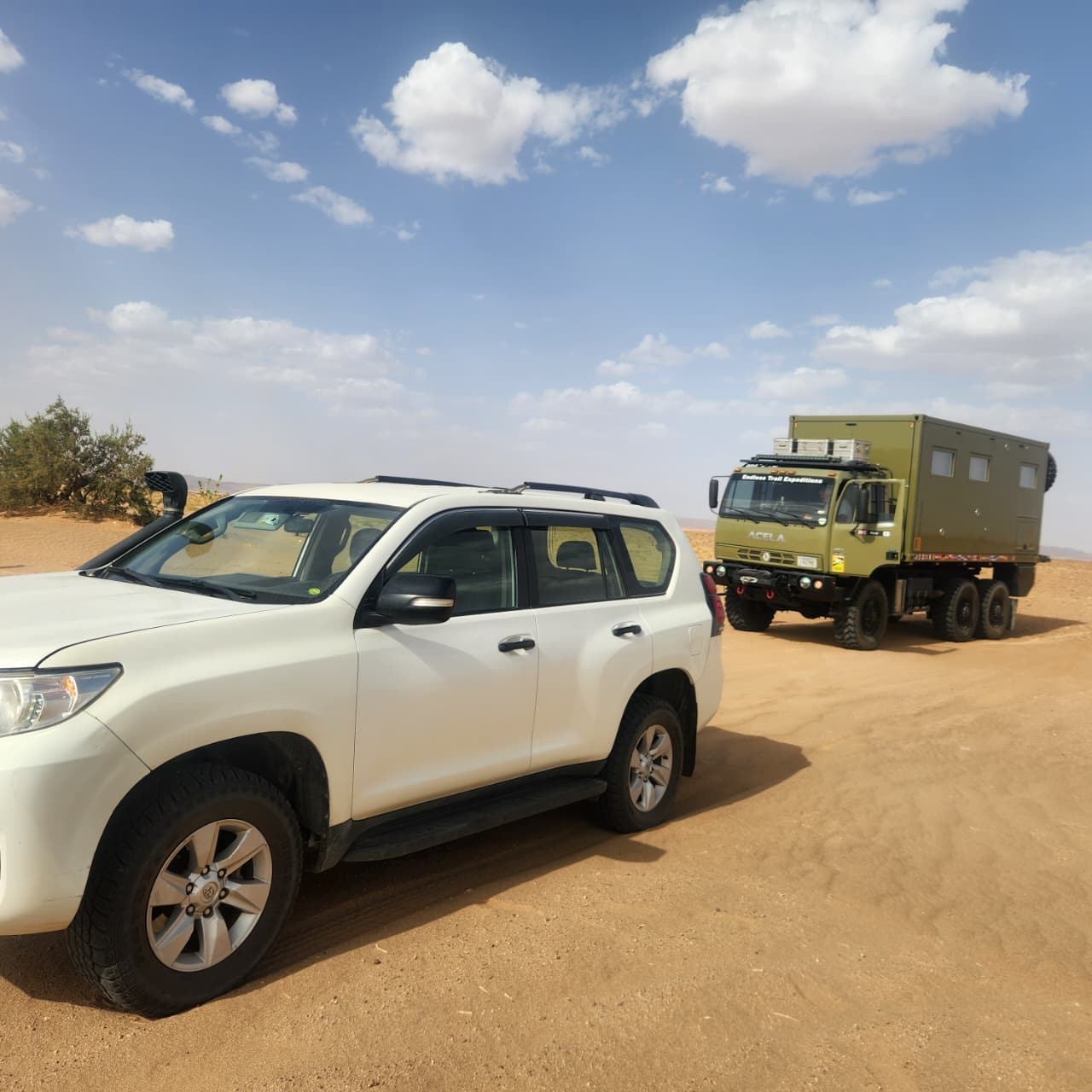 Land Cruiser and Acela 6x6 on a sand track