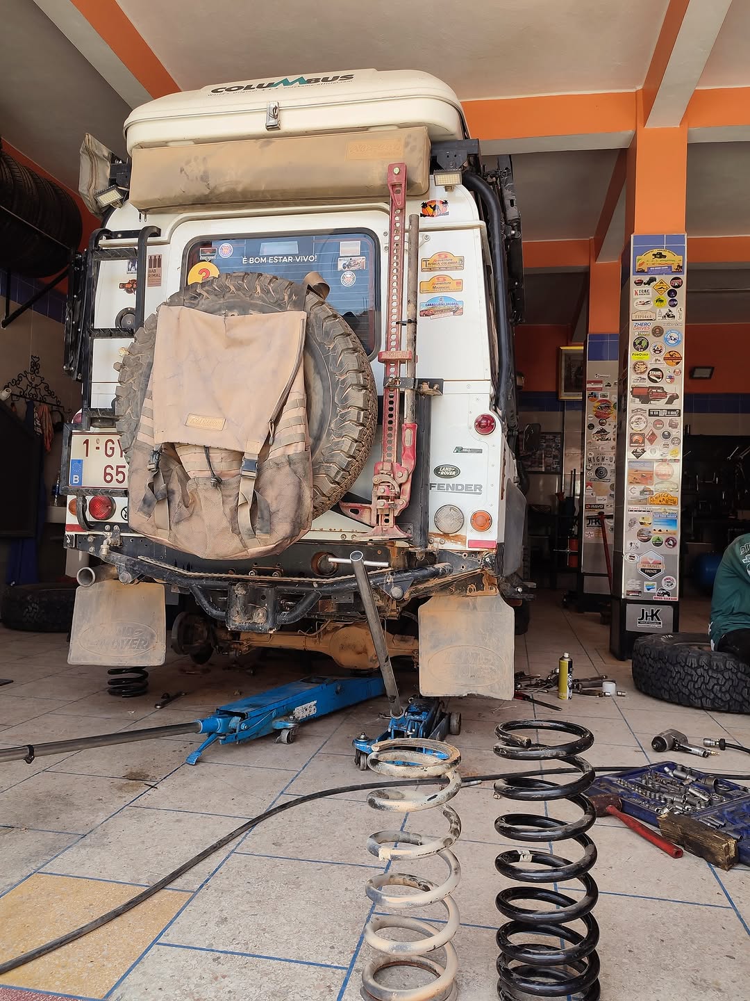 Rear view of the Belgian Land Rover Defender 110 with Columbus roof box and Belgian plate, rear axle dismounted for suspension reinforcement