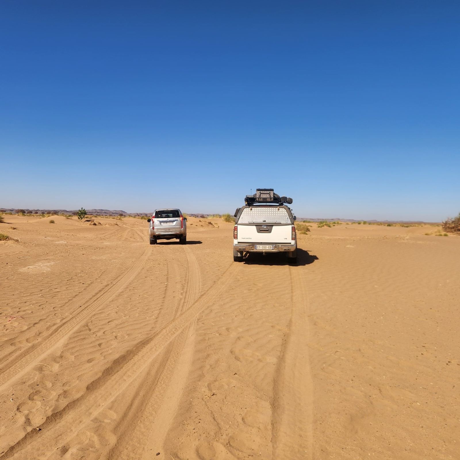 Silver SUVs on a sandy track