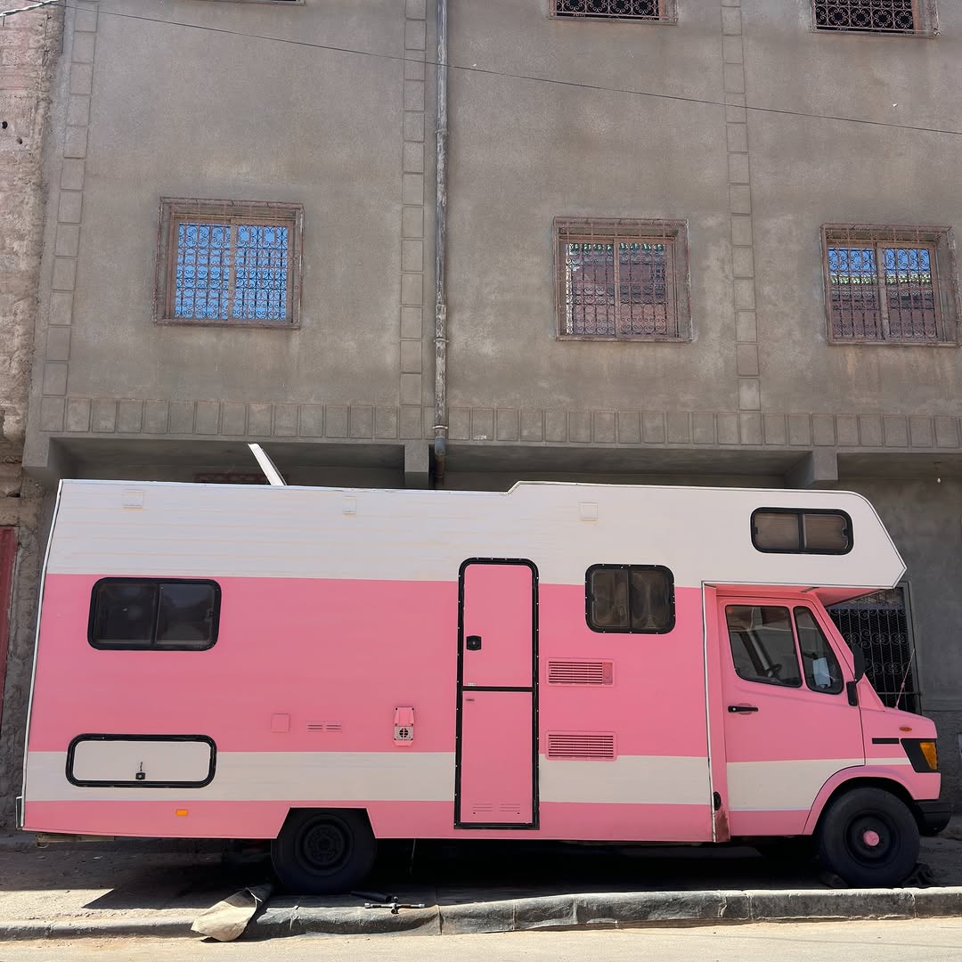Pink Mercedes 407D camper on a Zagora street after the front and rear leaf spring upgrade