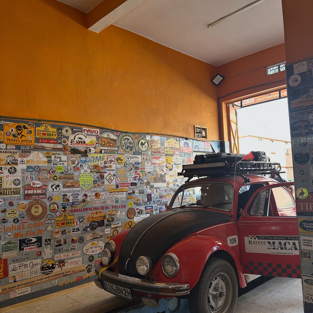 Rally VW Beetle inside Garage Iriki workshop in Zagora surrounded by the legendary rally sticker wall